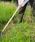 Person using Long Handle Weeding Sickle With Razor Sharp Japanese Carbon Steel Blade For Stand Up Weeding No Bending Easy Back Saving Yard Work 45 Inch Tool Made In Japan Great For Thick Weeds Gardens Lawns on overgrown grass