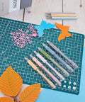 Lanties six-piece precision craft knife set with colored grips on a green cutting mat beside paper butterfly and leaf cutouts.