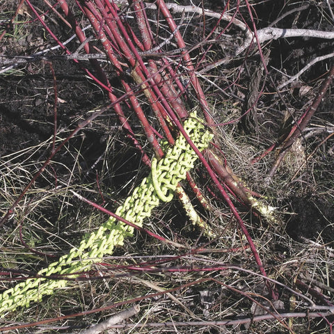 Heavy Duty Triple Chain Shrub And Clump Remover Tool gripping red branches for quick root and overgrowth extraction.