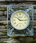 Vintage clock on rustic stone wall with decorative metal frame