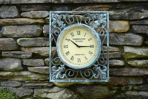 Vintage clock on rustic stone wall with decorative metal frame