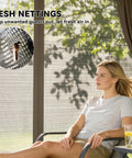 Woman relaxing on a chair inside 10 Foot By 12 Foot Outdoor Patio Gazebo With Double Roof, Curtains And Mesh Netting visible.