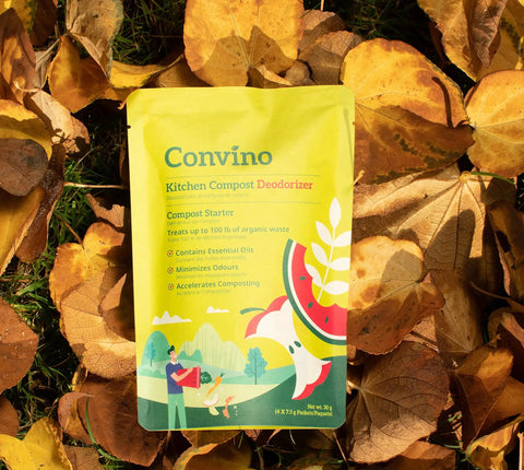 Package of Convino Kitchen Compost Deodorizer on leafy ground, labeled to treat 100 lb of waste and minimize odors.