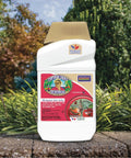 Deadbug Brew Insecticide Concentrate For Outdoor Gardens 32 Oz bottle on garden ledge with trees in background