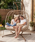 Double Hanging Egg Chair With Stand For Patio Or Balcony Oversized Two Person Outdoor Swing With Thick Cushions And All Weather Wicker Loveseat Beige with family sitting.