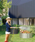 Woman watering plants in Two Pack 2x2x1 Foot Galvanized Raised Garden Bed Planter Set For Backyard Veggies And Flowers