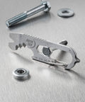DoohicKey Keychain Multi Tool Stainless Steel 8 In 1 Bottle Opener on metal surface with screws and washers