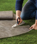 Person cutting Tyvek on grass using PowerArc 8 Inch Heavy Duty Shop Shears With Serrated Stainless Steel Blades And Comfort Grip