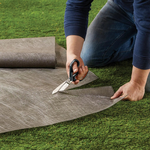 Person cutting Tyvek on grass using PowerArc 8 Inch Heavy Duty Shop Shears With Serrated Stainless Steel Blades And Comfort Grip