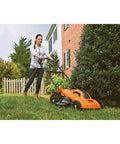 Person using a Corded Electric Push Lawn Mower With 13 Amp Motor, 20-Inch Deck, 6-Position Height Adjustment on grass.