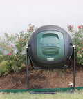 Front view of Ms Tumbles 35 Gallon Compost Tumbler with Easy Turn System, durable round design in black and green in a garden setting.