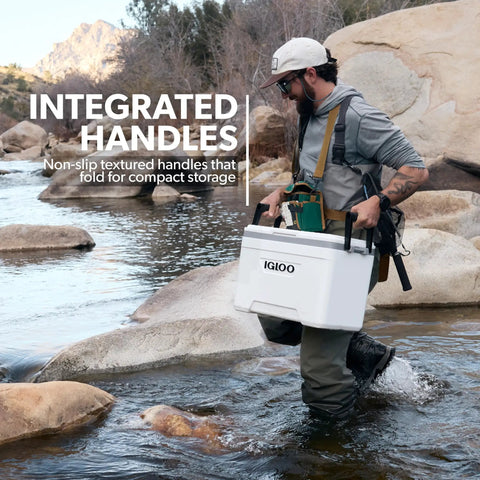 Person carrying Latitude Marine Ultra White 25 Quart Cooler With Cool Riser Technology ThermoCool Foam Insulation in rocky stream.