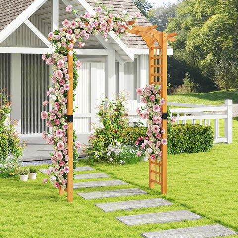 Arched-Top Wooden Garden Arch For Outdoor Use, 7.5 Ft Tall Trellis Arbor covered in pink roses, in a garden setting near a white house.
