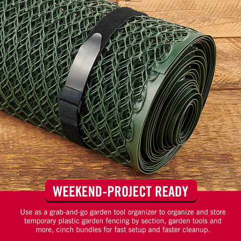 Rolled green garden fencing secured with a black 30 Inch Elastic Straps Four Pack For Yoga Mats Outdoor and more with D-ring buckle.
