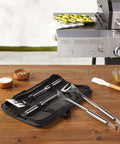 4 Piece Stainless Steel BBQ Grilling Tool Set with Carry Bag, including spatula, grill fork, tongs, and pouch, on wooden table