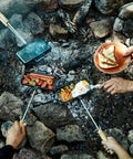 XL Cast Iron Pie Iron Sandwich Maker For Campfire Cooking with food over an open fire, showcasing outdoor use.