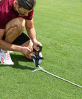 Man using Open Reel Measuring Tape With Easy Hand Crank And Metal Spike Dual Sided Feet And Meters Rugged Fiberglass Tape