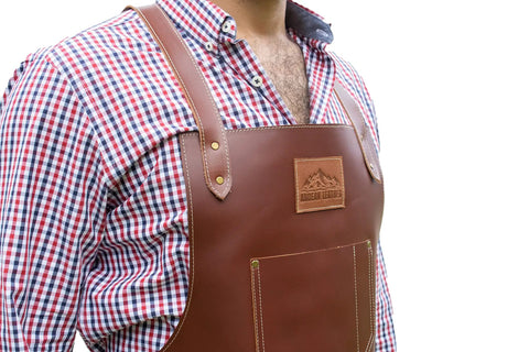 Person wearing Leather Grill Master Apron With Cross Back Straps Heat Resistant Full Grain Leather For BBQ Woodworking Barber And Welding