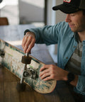 Man installing Premium Ceramic Bearings Set Of 8 For Skateboards Longboards Inline Skates And Rollerblades Featuring ZrO2 Ceramic Balls.