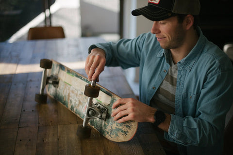 Man installing Premium Ceramic Bearings Set Of 8 For Skateboards Longboards Inline Skates And Rollerblades Featuring ZrO2 Ceramic Balls.