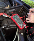 Using Auto Range Digital Multimeter With NCV, Backlit LCD for car diagnostics, connected to engine bay showing 9.041 reading.