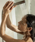 Woman enjoying a shower with instant hot water from Score Instant Hot Water With This Beast-Mode 26.9 KW Electric Tankless Water Heater.