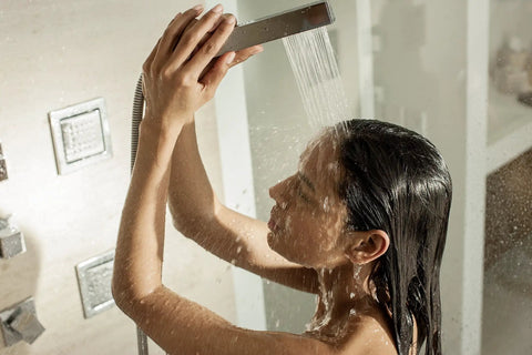 Woman enjoying a shower with instant hot water from Score Instant Hot Water With This Beast-Mode 26.9 KW Electric Tankless Water Heater.