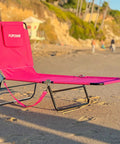 Pink 2 Leg Chaise Lounge Chair With Polyester Comfort, Reclining Back, Headrest Pillow on beach with compact frame
