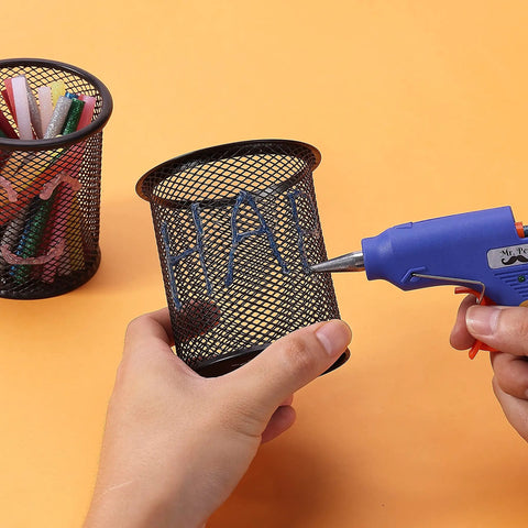 Using Glitter Hot Glue Sticks 4 By 0.27 Inch Mini Colored 48 Pack For Hot Glue Gun on mesh pen holder on orange background
