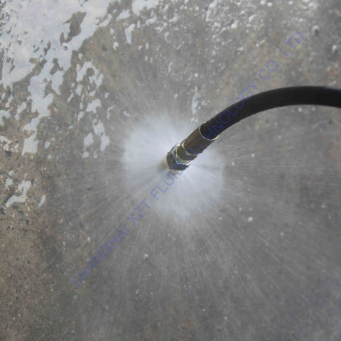 7 Pack 4000 PSI Sewer Jetter Nozzle Kit with Rotating Button Nose in use spraying water on concrete surface