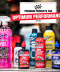Assorted Finish Line bike care products, including lubricants and washes, displayed on a table with racing-inspired packaging.