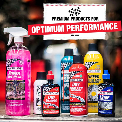 Assorted Finish Line bike care products, including lubricants and washes, displayed on a table with racing-inspired packaging.