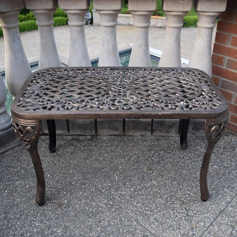 Mississippi Cast Aluminum Outdoor Cocktail Table 35 Inch Long By 18 Inch Wide In Antique Bronze on patio near pool