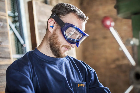Man wearing Odyssey II Eye Protection Goggles for Work. Blue frame safety goggles with clear lenses and neoprene headband.