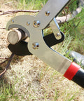Workhorse 29 Inch Anvil Lopper Pruner cutting a branch with spare SK5 blade and ergonomic non-slip handles in grass
