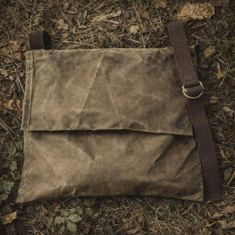 Top view of XL Haversack Foraging Bag Waxed Canvas Bushcraft Messenger With Reinforced Straps Durable Vintage Look in natural setting.