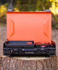 2364 12 By 14 Camping Griddle With Side Burner Nonstick Ceramic Titanium Coated Surface on a tree stump in forest setting