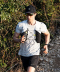 Runner wearing 5L Hydration Running Vest With Dual 500ml Soft Flasks, Lightweight Nylon Pack, Adjustable Chest Straps on a trail