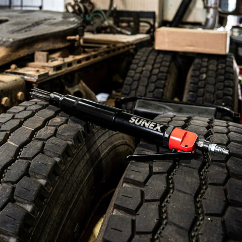 Beast Heavy Duty Air Needle Scaler shown on truck tire, ideal for surface prep, rust and paint removal with 1-1/8 inch stroke.