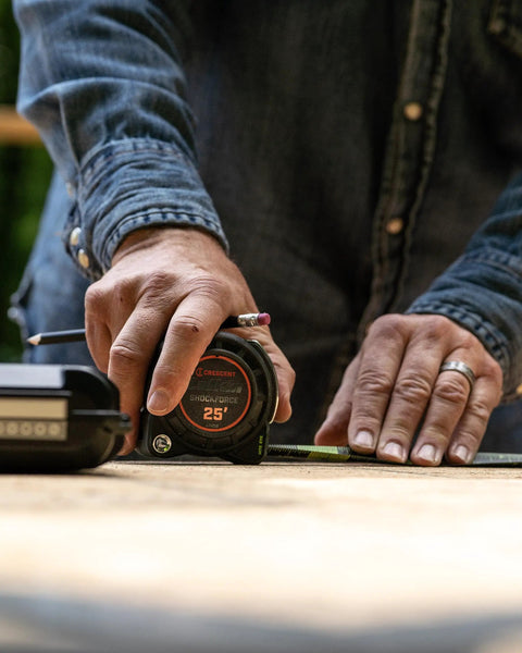 Person using 1-3/16 Inch By 25 Foot Dual Sided Tape Measure With Nite Eye Glow on a job site