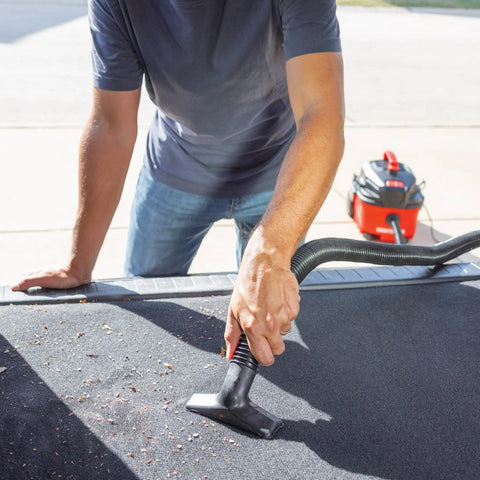 Pro-Grade 1-1/4 In Wet Dry Shop Vac Attachment Kit With Reinforced 11 Ft Hose. Man vacuuming car upholstery with attachment.