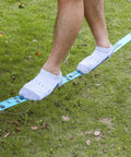 Person balancing on Beginner Slackline Kit With 50 Foot Main Line And Training Line in backyard