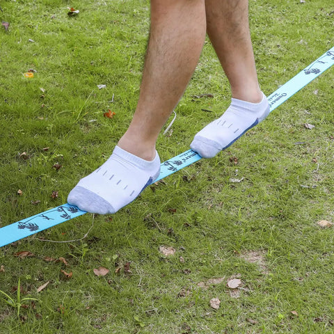Person balancing on Beginner Slackline Kit With 50 Foot Main Line And Training Line in backyard