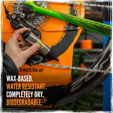 Person applying BananaSlip Tungsten All Weather Lube For Road Mountain Race And EBike Use Wax Based Water Resistant Dry Formula Biodegradable Lubricant In 50ml Bottle to a bike chain