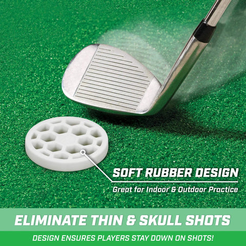 Golf club striking a white rubber training disc on green turf, design for eliminating thin and skull shots, suitable for indoor and outdoor practice.