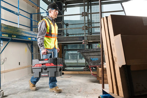 Worker carrying ProPack 4.5 Gallon Portable Wet Dry Shop Vacuum With Toolbox Design For Easy On The Go Cleanup at job site