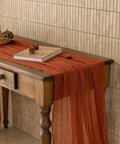 Rustic Fall Thanksgiving Table Runner Terracotta Cheesecloth Weave 120 Inches Long Hand Dyed Soft Cotton Gauze on wooden table.