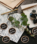 Premium Unfinished Wood Cutout Circles 1.5 Inches for art projects on table with eucalyptus and writing tools.