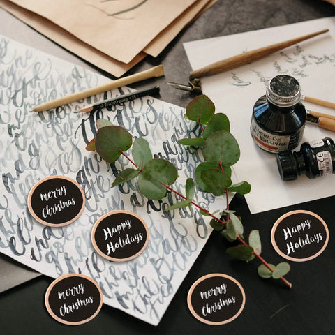 Premium Unfinished Wood Cutout Circles 1.5 Inches for art projects on table with eucalyptus and writing tools.