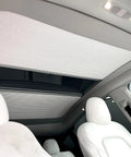 Fully Retractable Aluminum Sunroof Sunshade For Tesla Model Y shown inside cabin, blocking sunlight on panoramic roof.